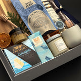 Fireside Provisions corporate holiday gift by Muse Baskets and Co., featuring an acacia board, Winter Wellness Tea and Drizzle honey.