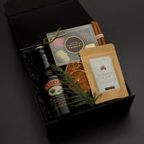 The Parlour holiday gift box by Muse Baskets and Co. with Baileys, assorted chocolates, hot chocolate, cinnamon sticks, evergreen styling and satin ribbon.