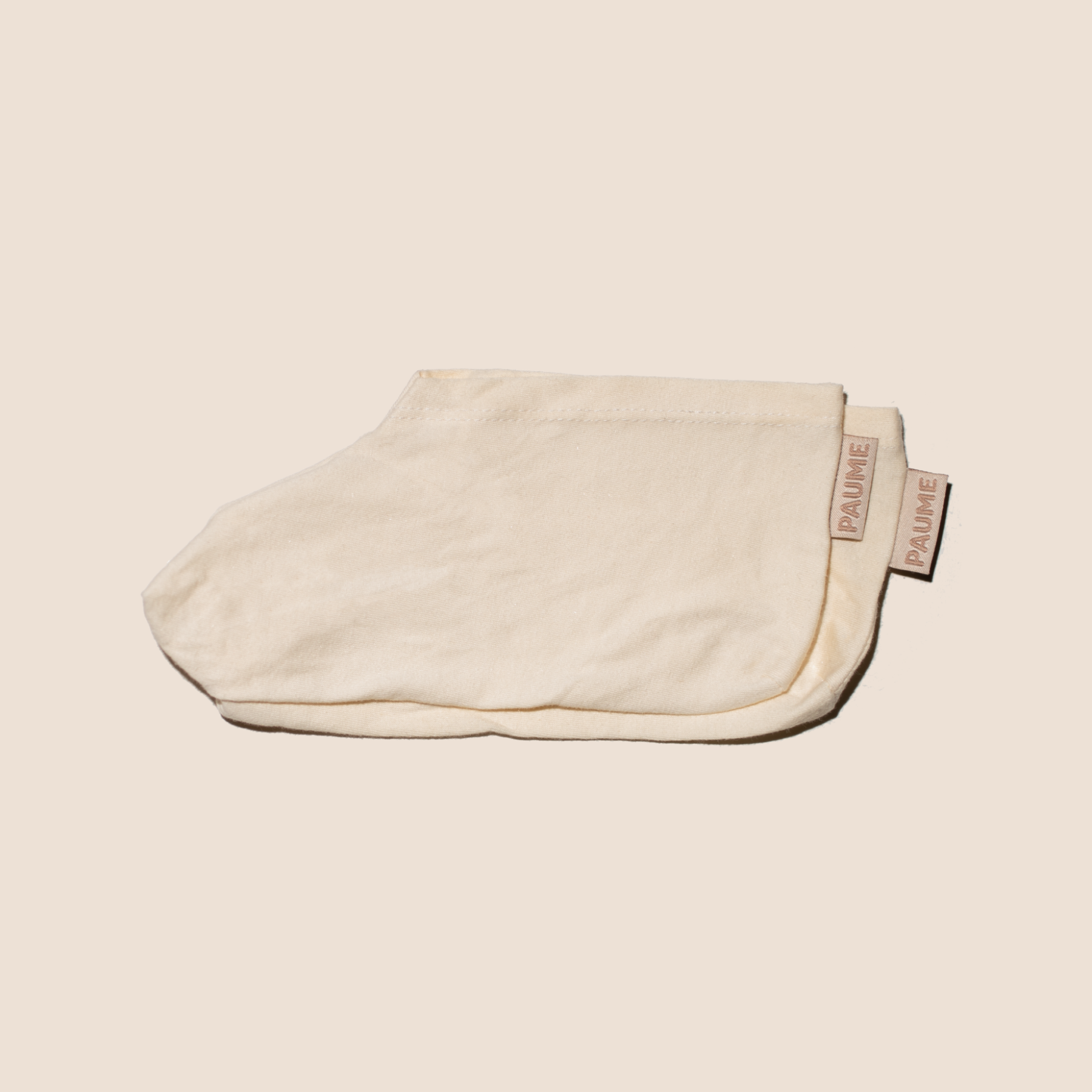 Beige cotton socks with a Paume brand label on a beige background