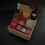Gift basket with various items including a bottle of wine on a dark background