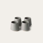 Four gray ceramic cups on a white background