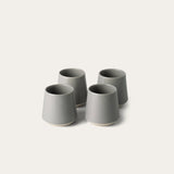 Four gray ceramic cups on a white background
