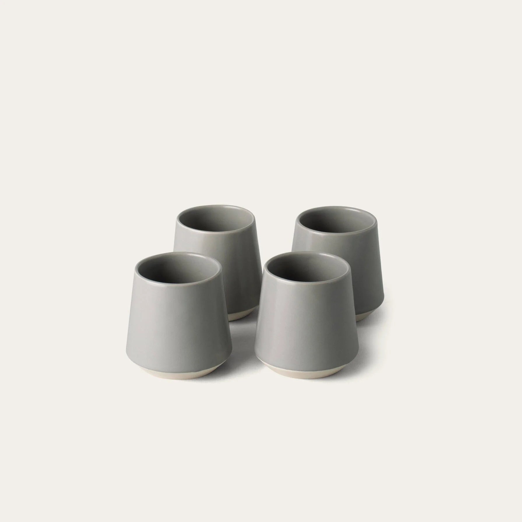 Four gray ceramic cups on a white background