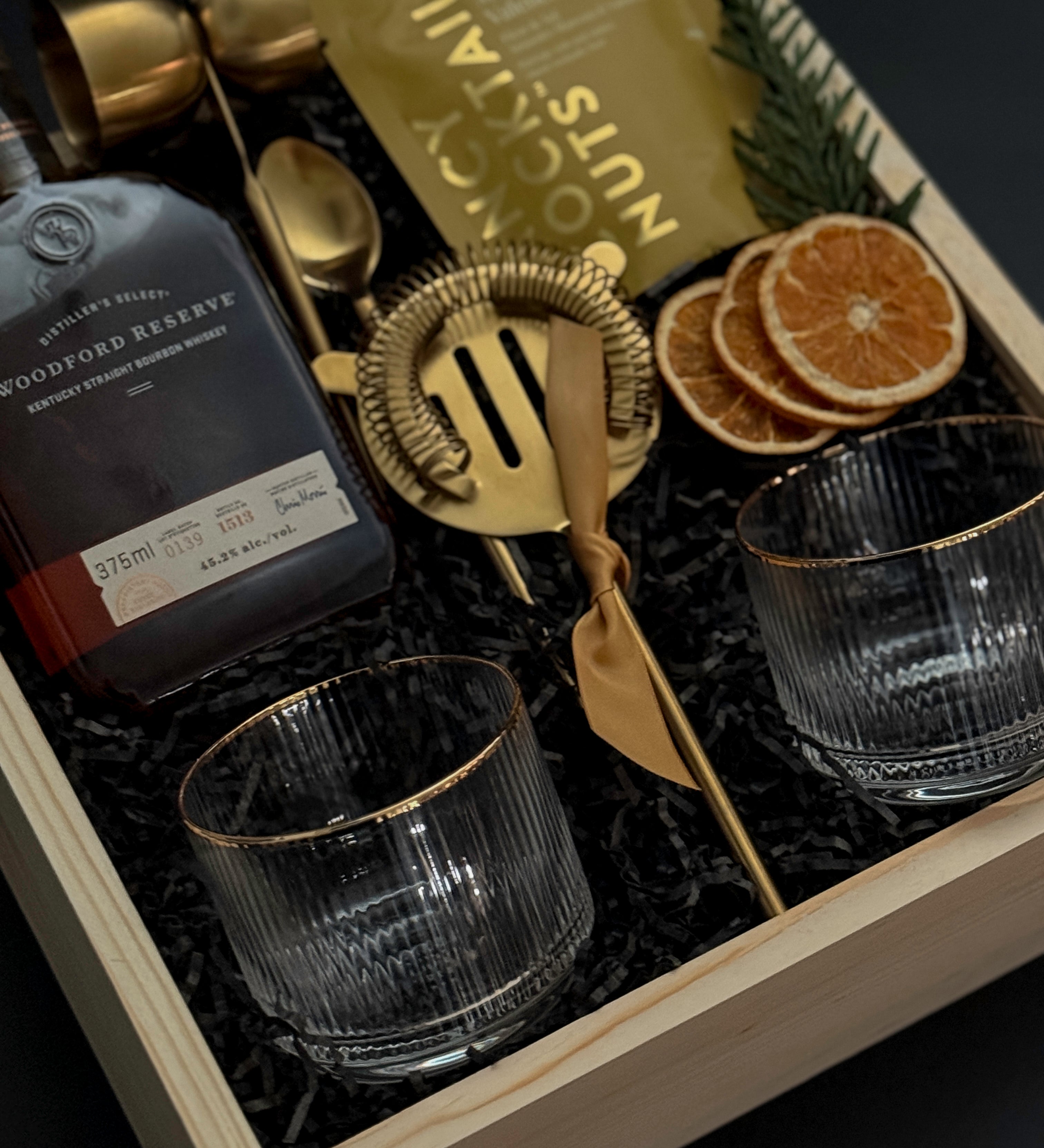 Corporate whiskey gift box featuring bourbon, Viski glasses, almonds, and festive details.