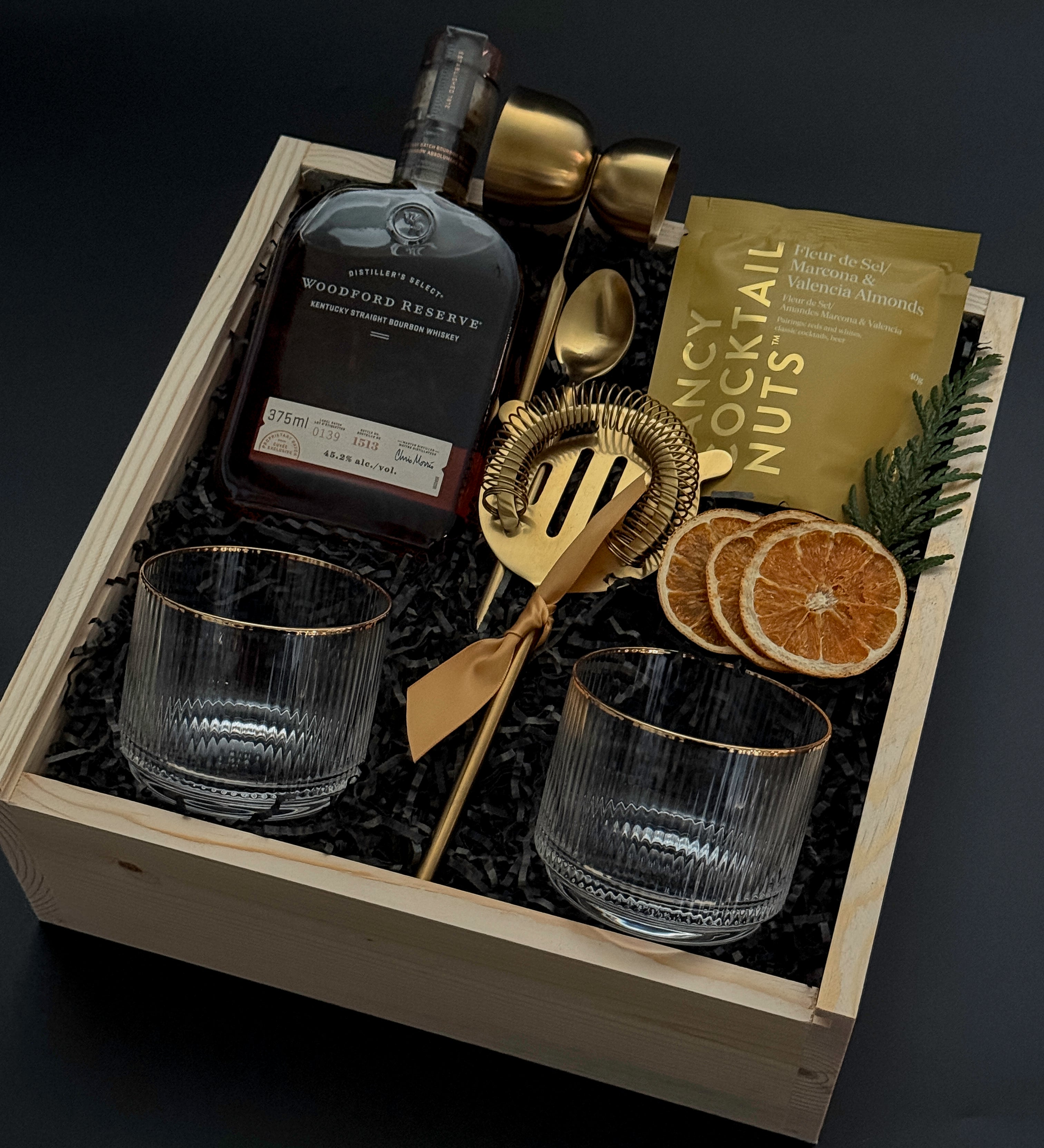 Corporate whiskey gift box featuring bourbon, Viski glasses, almonds, and festive details.