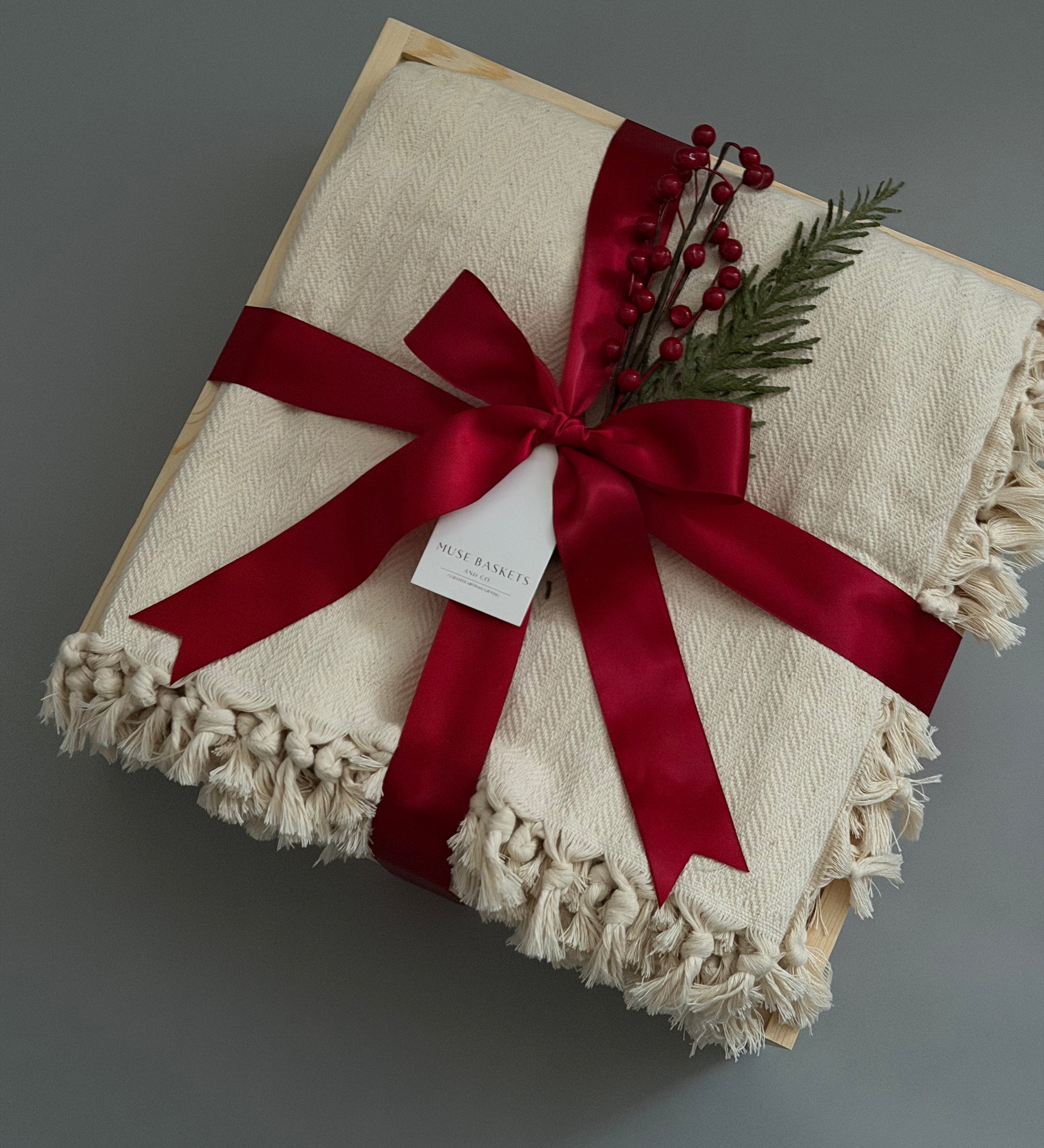 Closed gift box with cream blanket and holiday decorations, perfect for  corporate clients and colleagues.