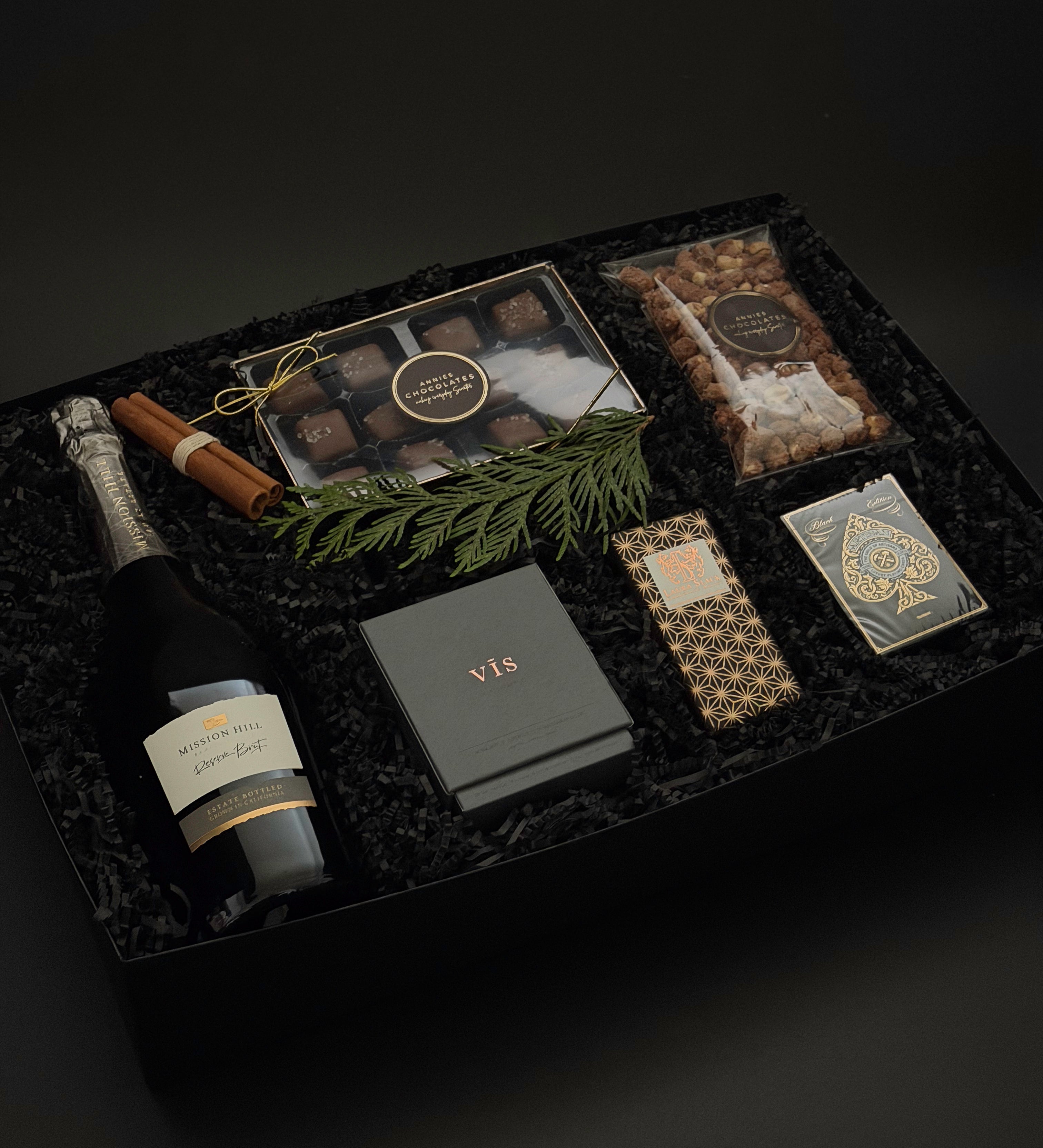 St. James Reserve by Muse Baskets and Co., an executive holiday gift with Mission Hill Brut, candle, caramels, nuts and playing cards.