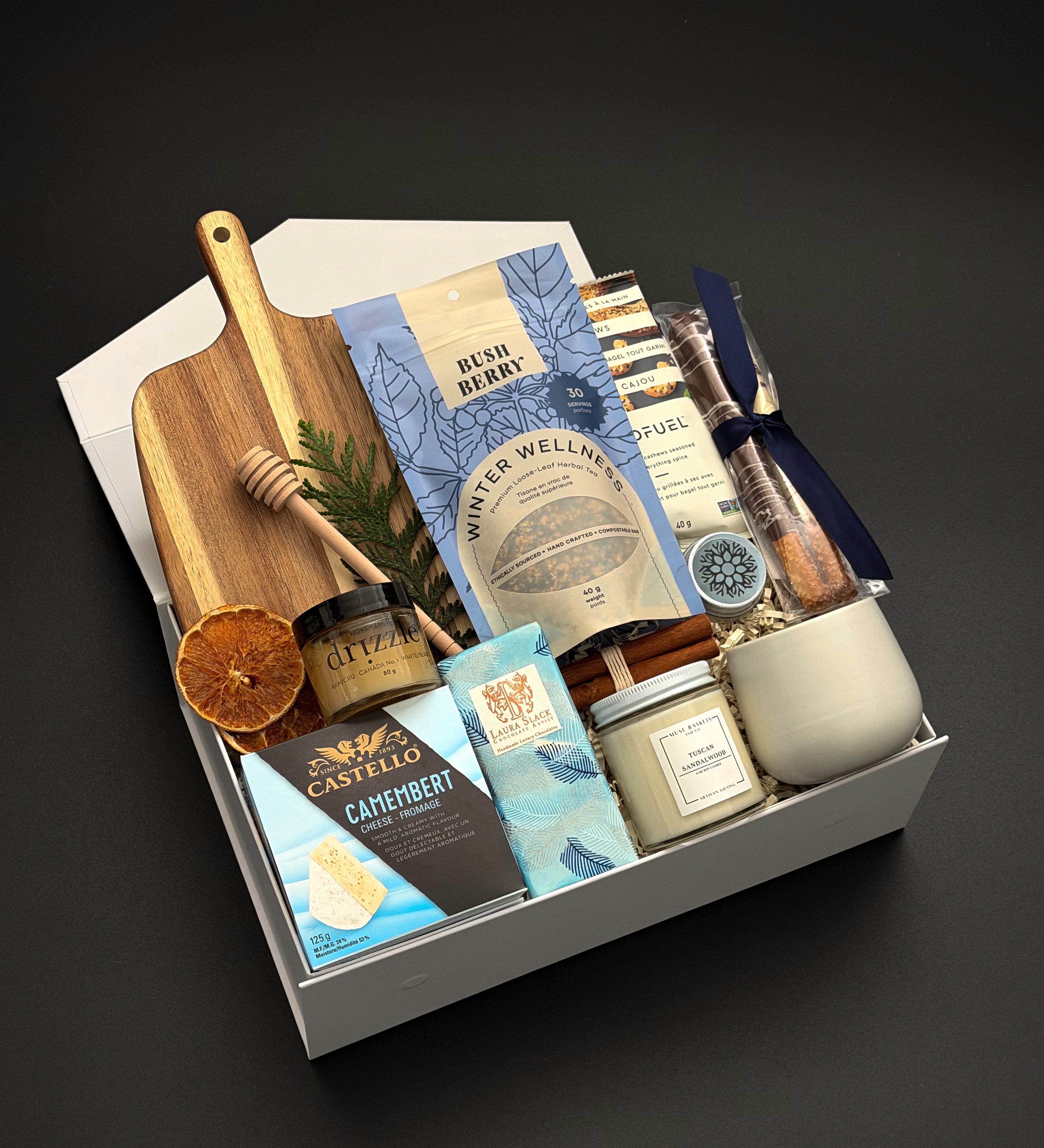 Fireside Provisions holiday gift box by Muse Baskets and Co., with tea, honey, artisan chocolate and stoneware in a Signature Pearl White gift box.