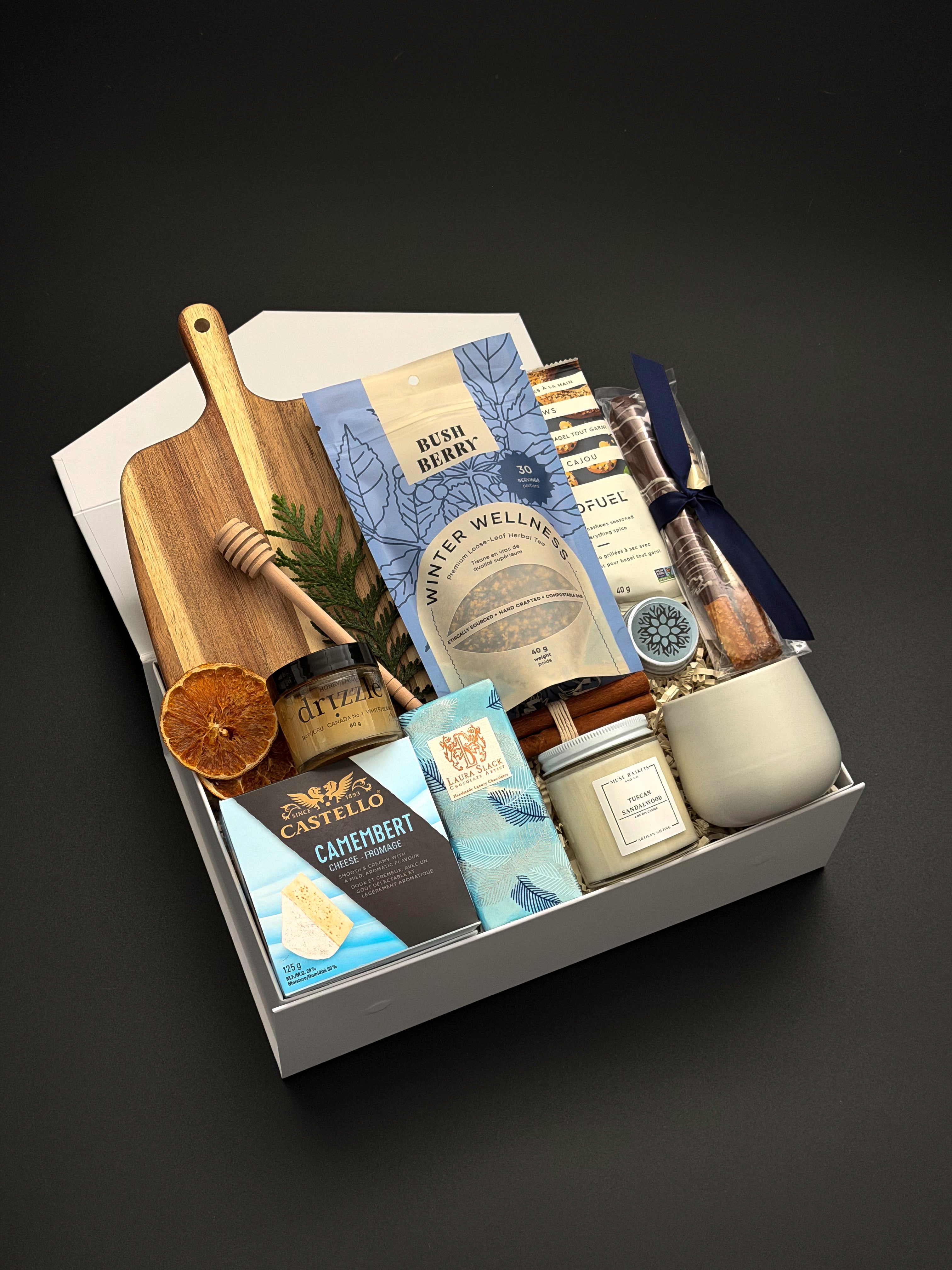 Fireside Provisions holiday gift box by Muse Baskets and Co., with tea, honey, artisan chocolate and stoneware in a Signature Pearl White gift box.