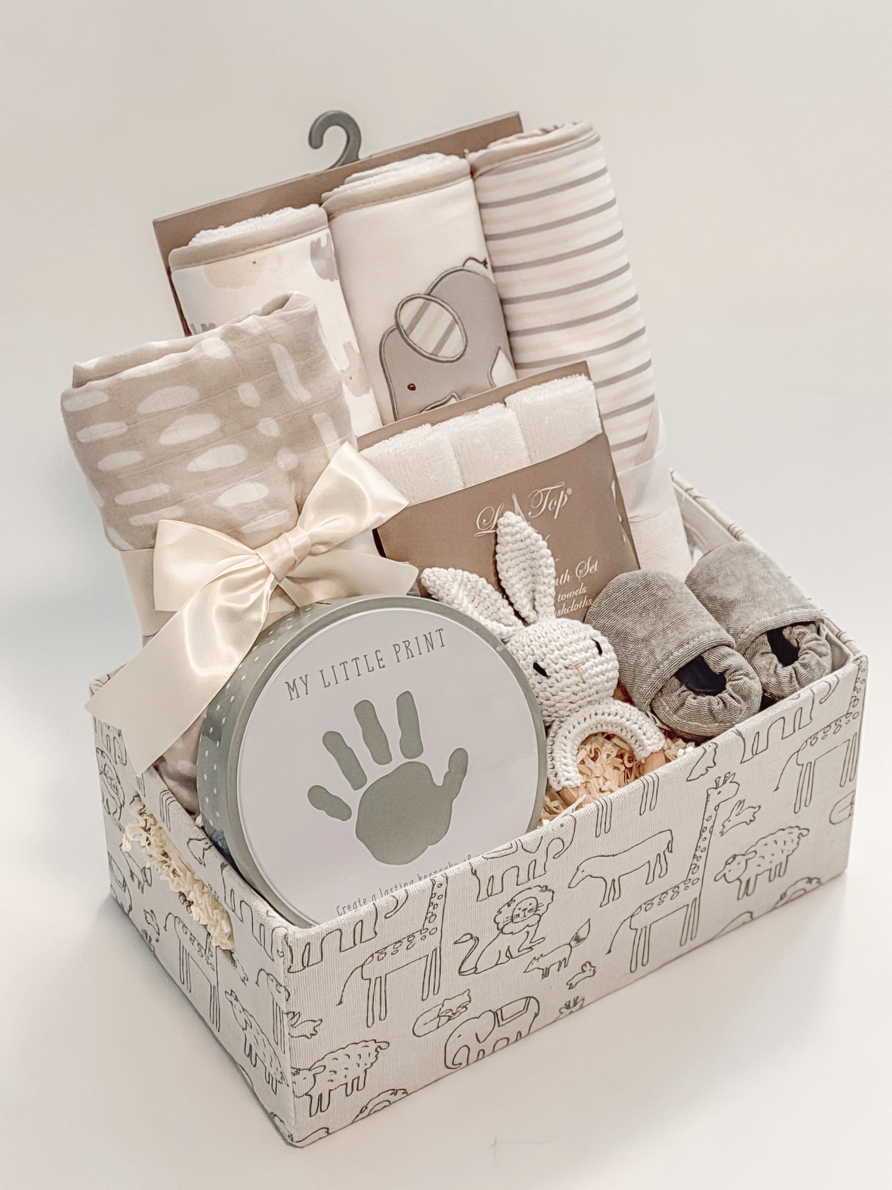 side view of Our Little World baby gift basket with gray animal safari keepsake basket and satin ribbon