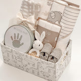 side view of curated newborn gift basket with Loulou Lollipop swaddle and My Little Print keepsake kit