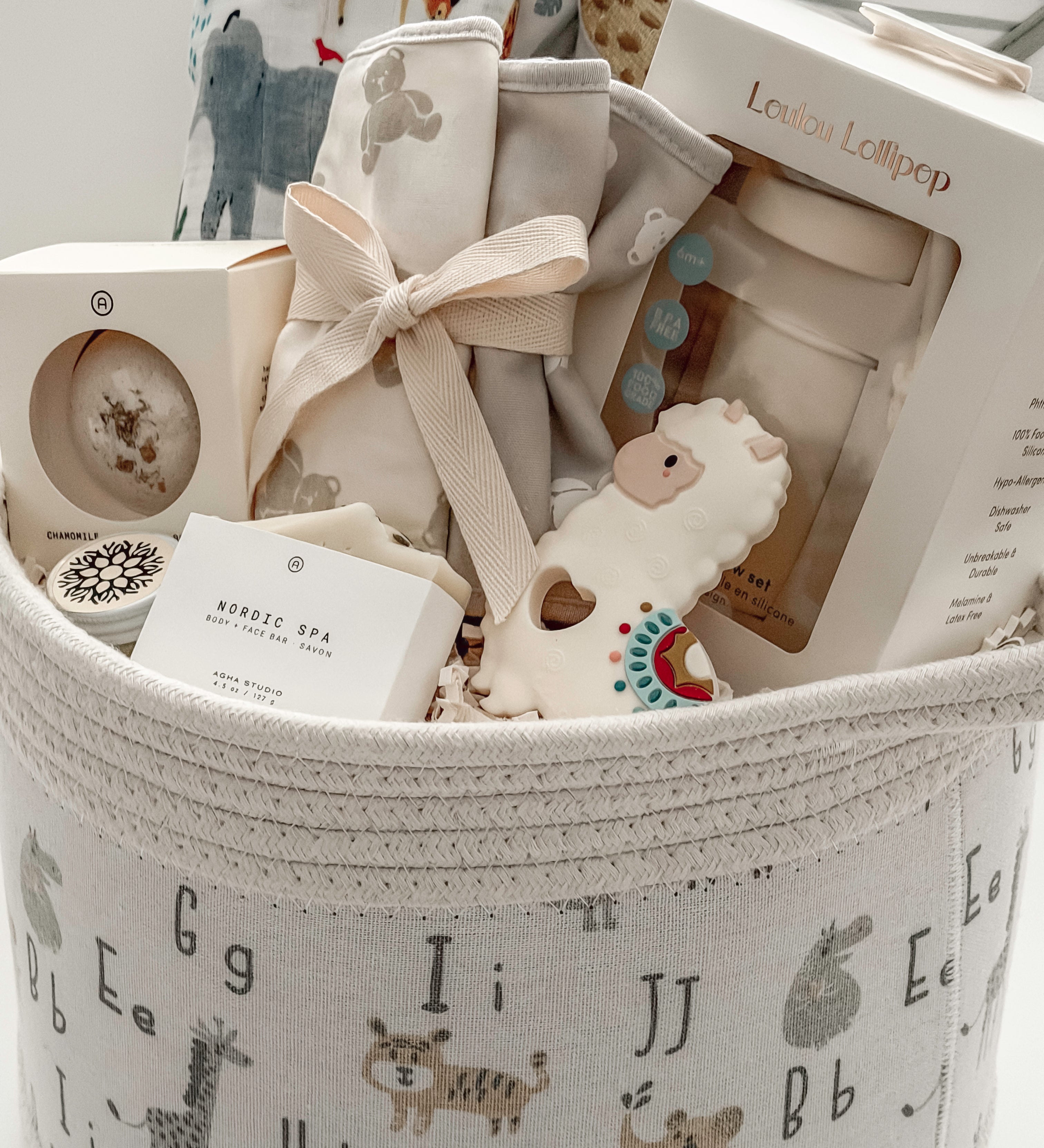 Neutral baby shower gift basket with Loulou Lollipop swaddle, teether and baby accessories