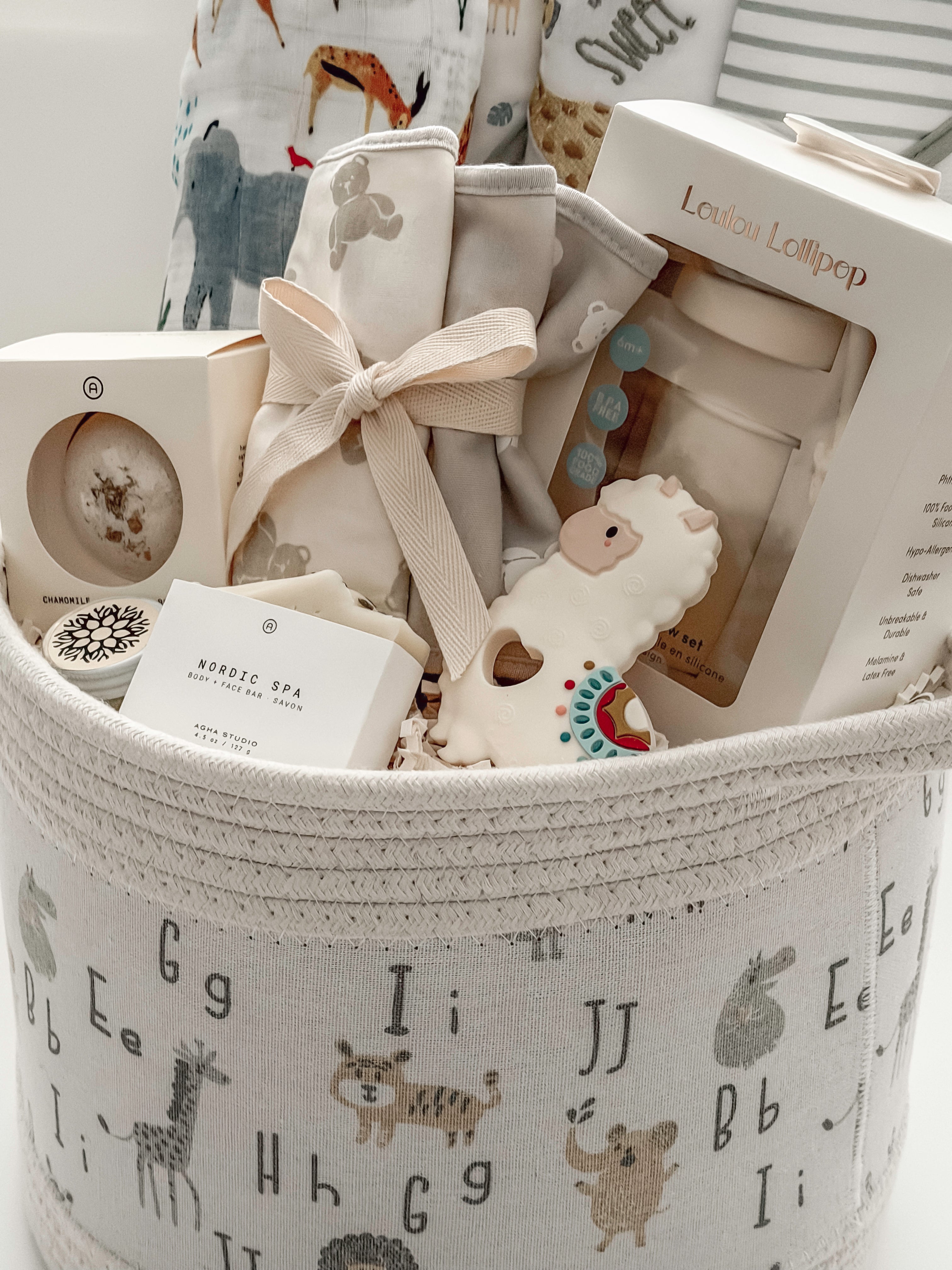 Neutral baby shower gift basket with Loulou Lollipop swaddle, teether and baby accessories