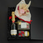 Luxury champagne gift box featuring Moët & Chandon, preserved florals, gourmet chocolates, and candle in a signature black gift box