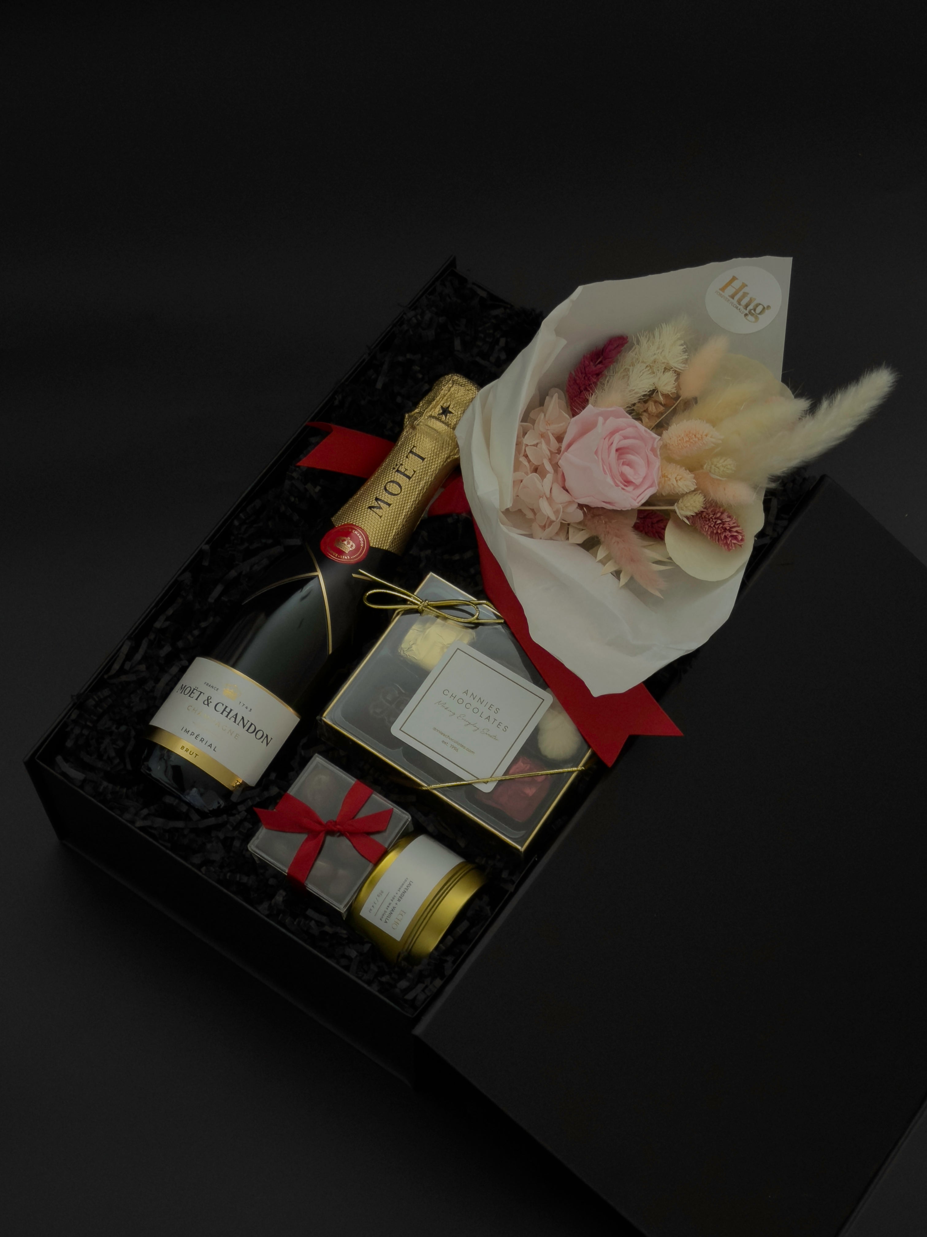 Preserved floral bouquet with soft blush tones paired with champagne and chocolates in a luxury gift box