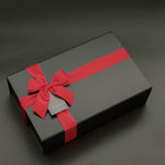 Signature black gift box with satin ribbon, preserved florals, and premium champagne curated for an elevated gifting experience