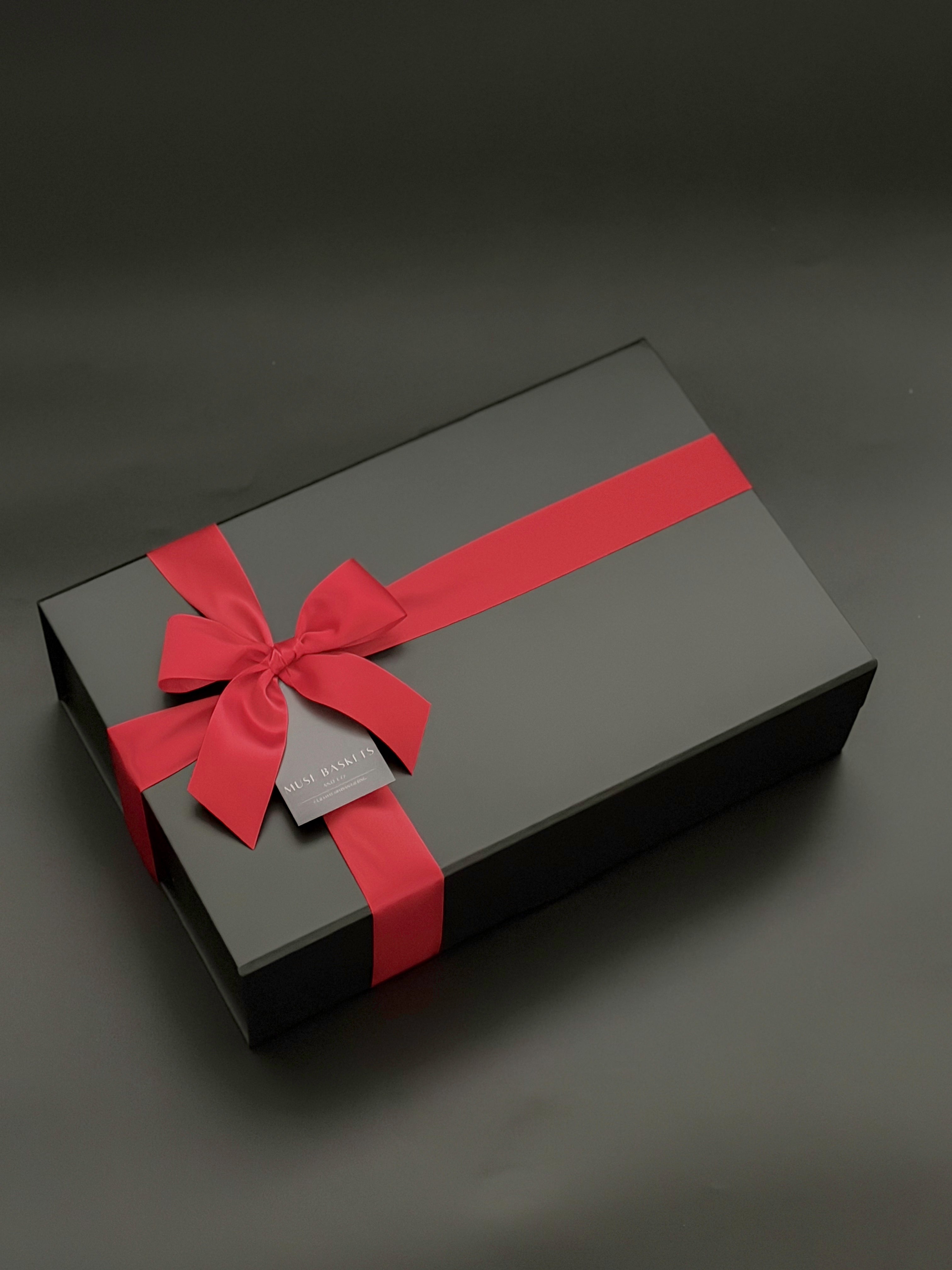 Signature black gift box with satin ribbon, preserved florals, and premium champagne curated for an elevated gifting experience