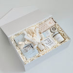 Gift set with candles, soap, and other items in a white box on a light gray background