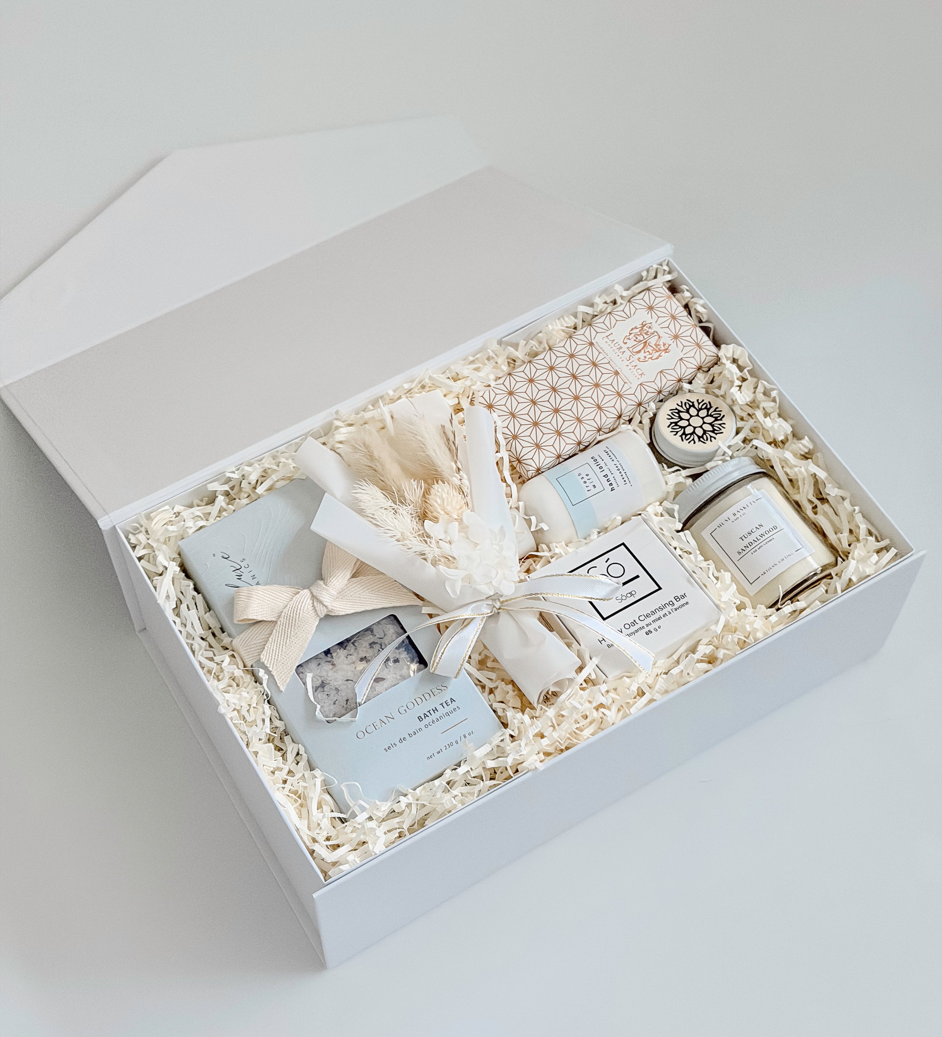 Gift set with candles, soap, and other items in a white box on a light gray background
