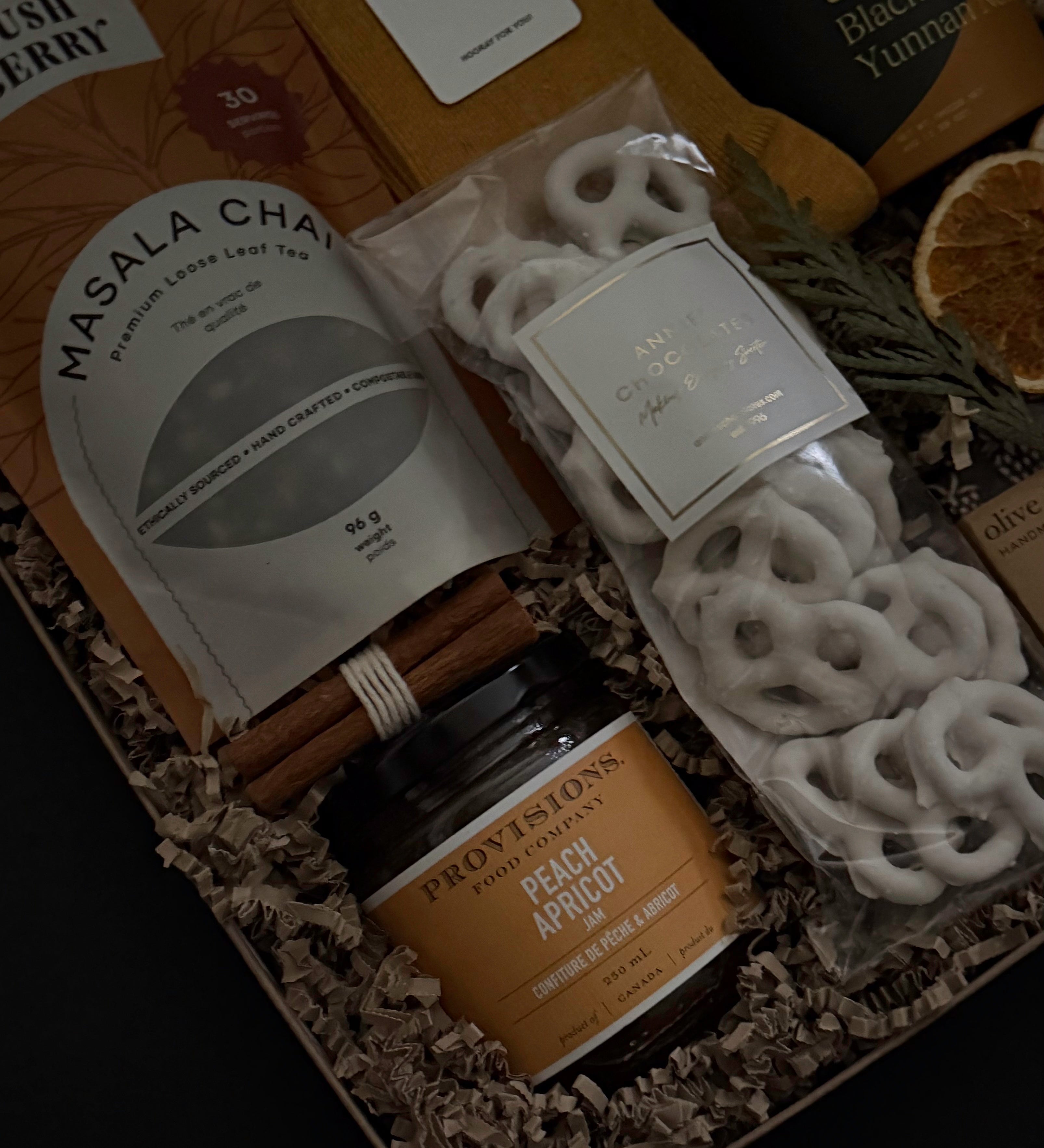 Wellness gift set with loose leaf chai tea, biscuits, socks and gourmet jam in kraft box.