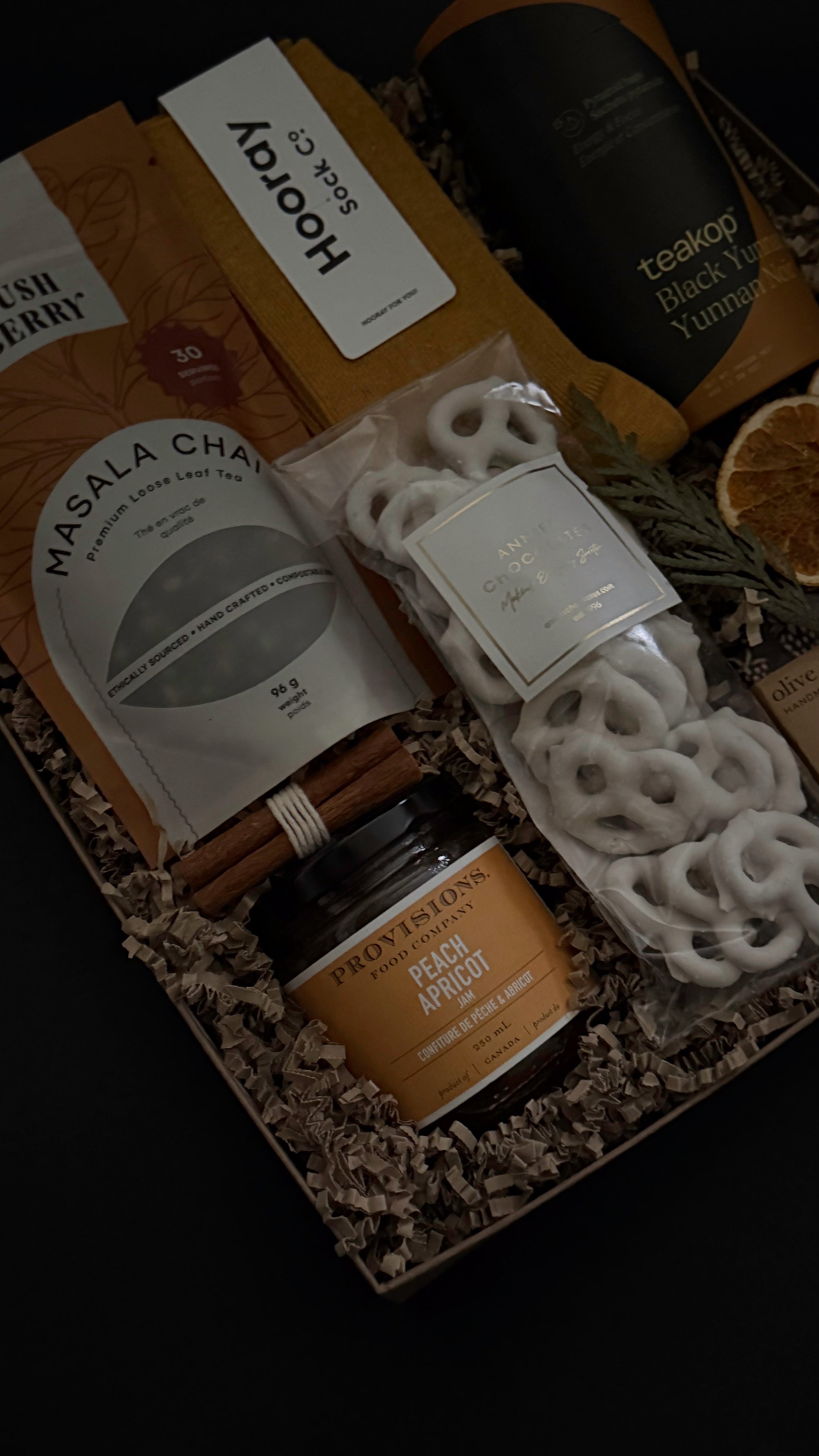 Wellness gift set with loose leaf chai tea, biscuits, socks and gourmet jam in kraft box.