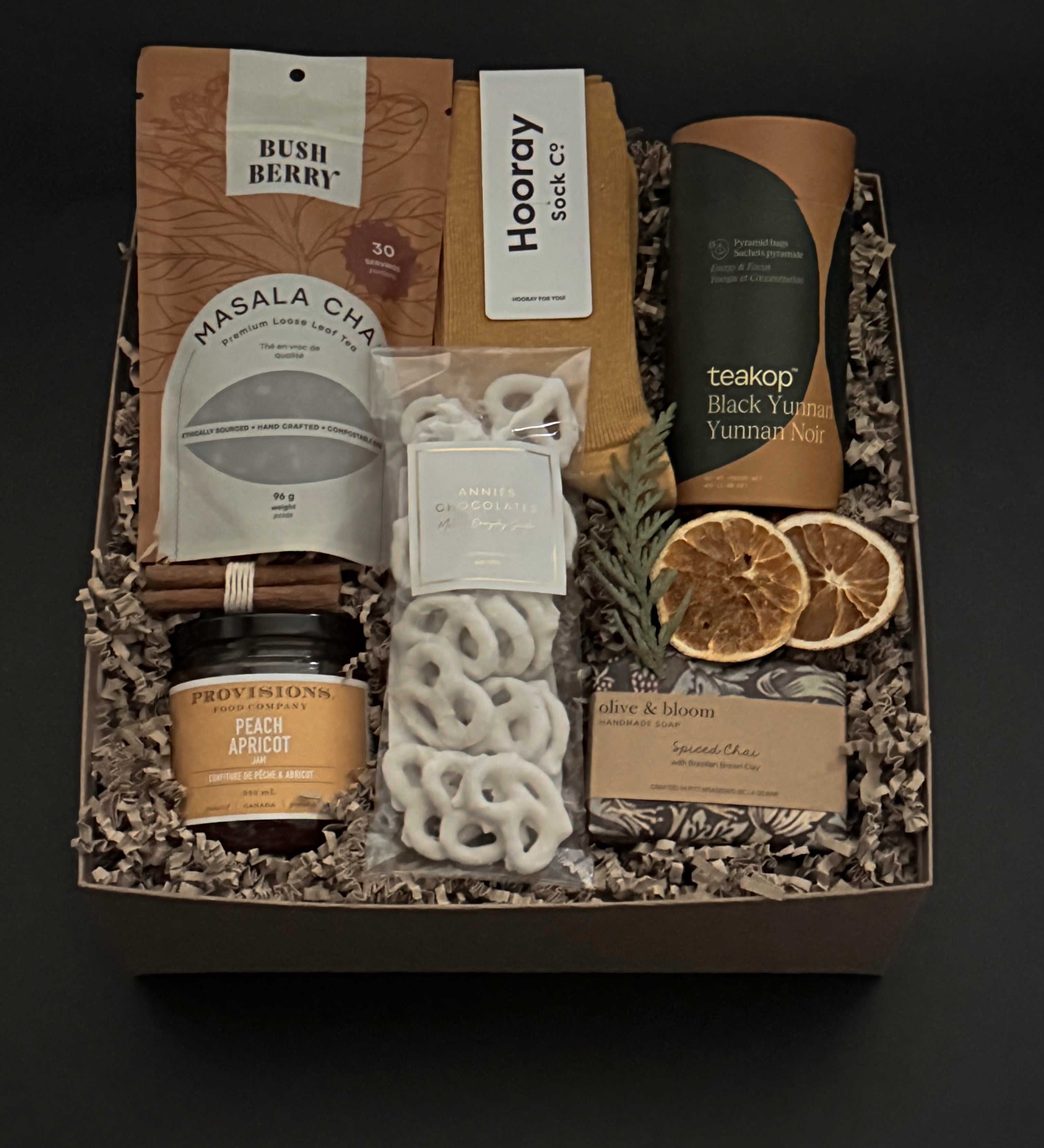 Curated winter tea gift box with chai, cozy socks, artisan chocolate and pretzels by Muse Baskets and Co.