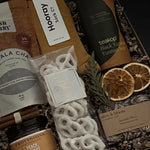 Corporate wellness and appreciation gift featuring tea, socks, and artisan sweets.