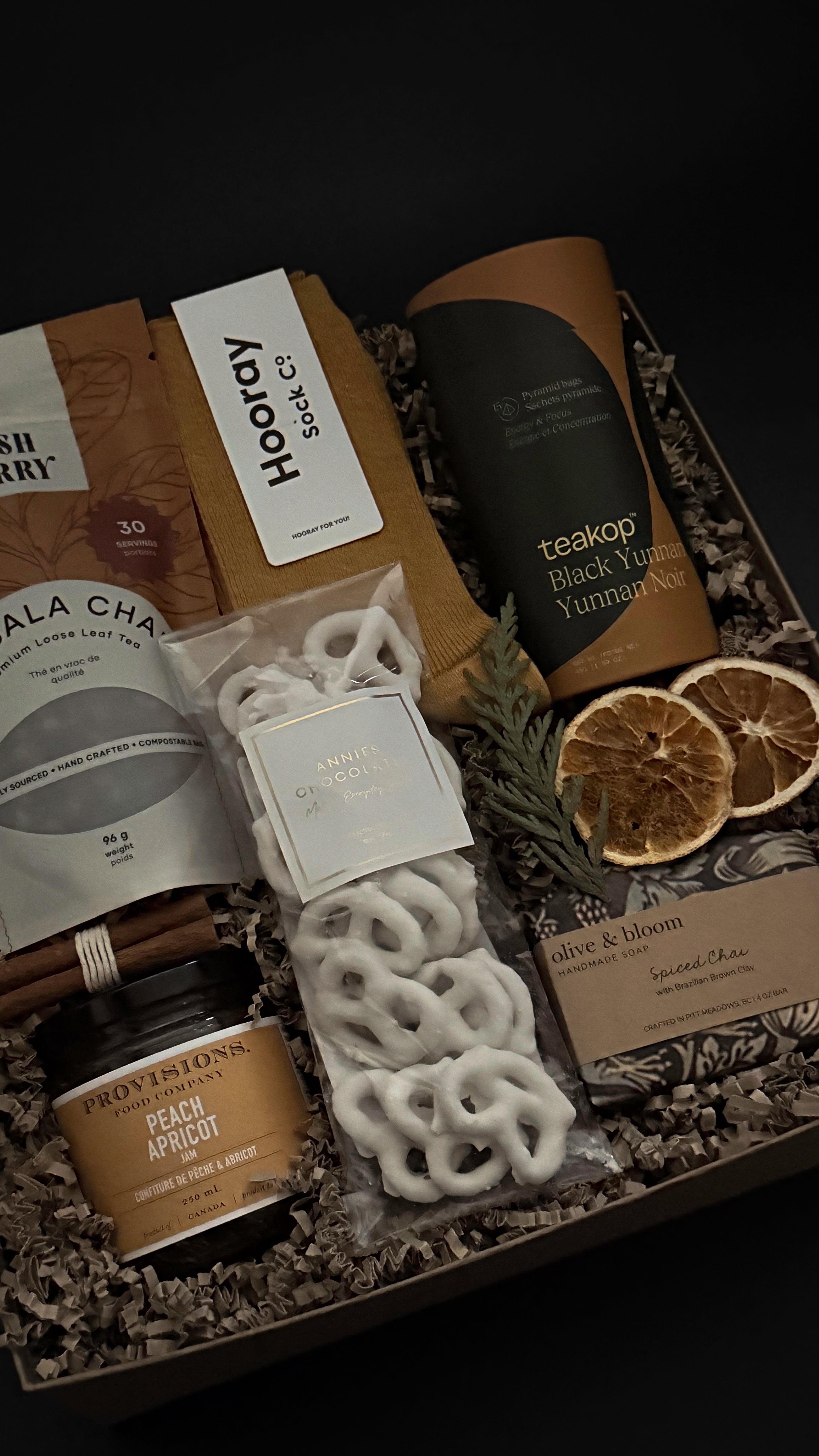 Corporate wellness and appreciation gift featuring tea, socks, and artisan sweets.