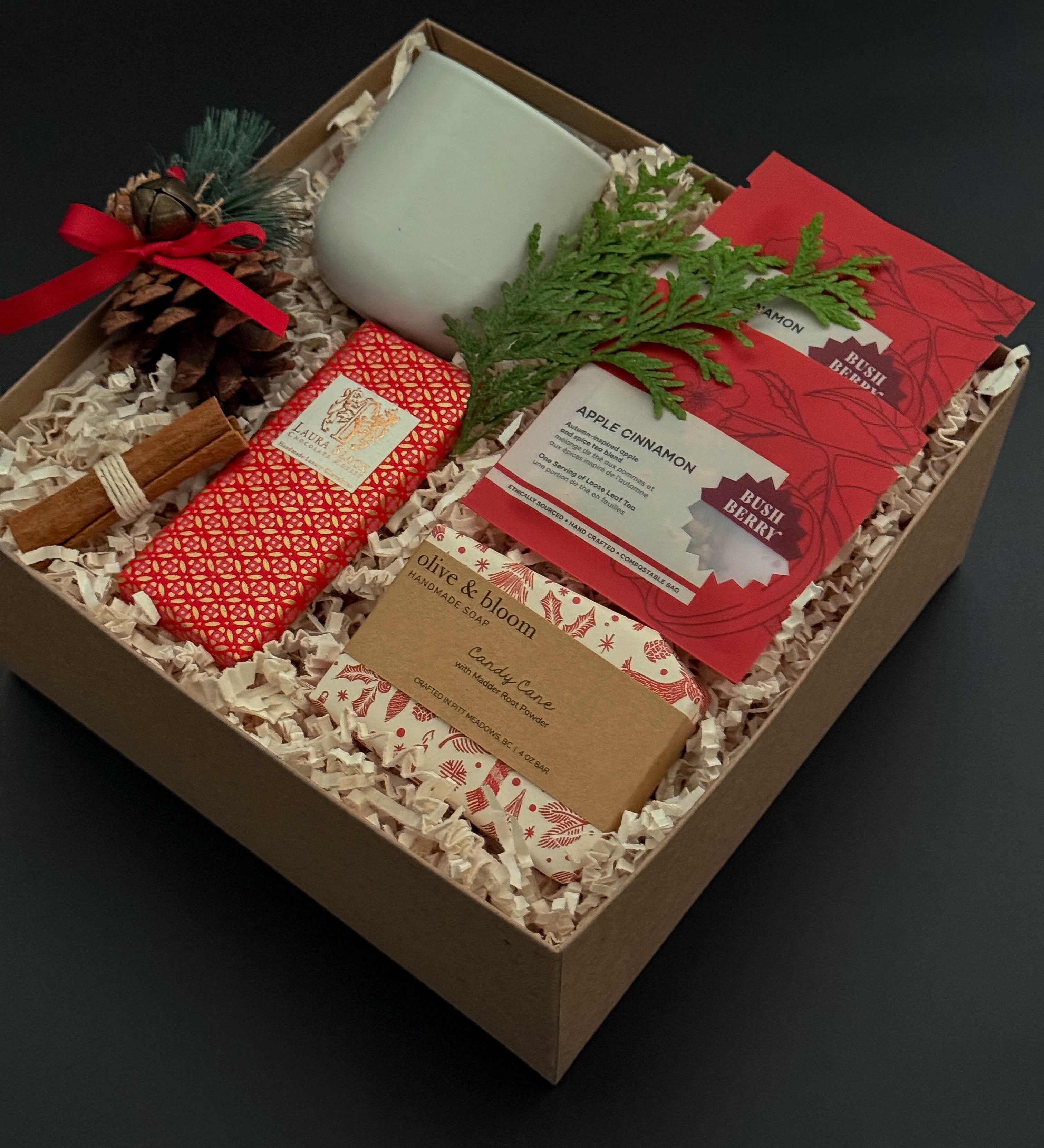 Corporate holiday gift box with stoneware cup, candy cane soap, chocolate, and greenery.