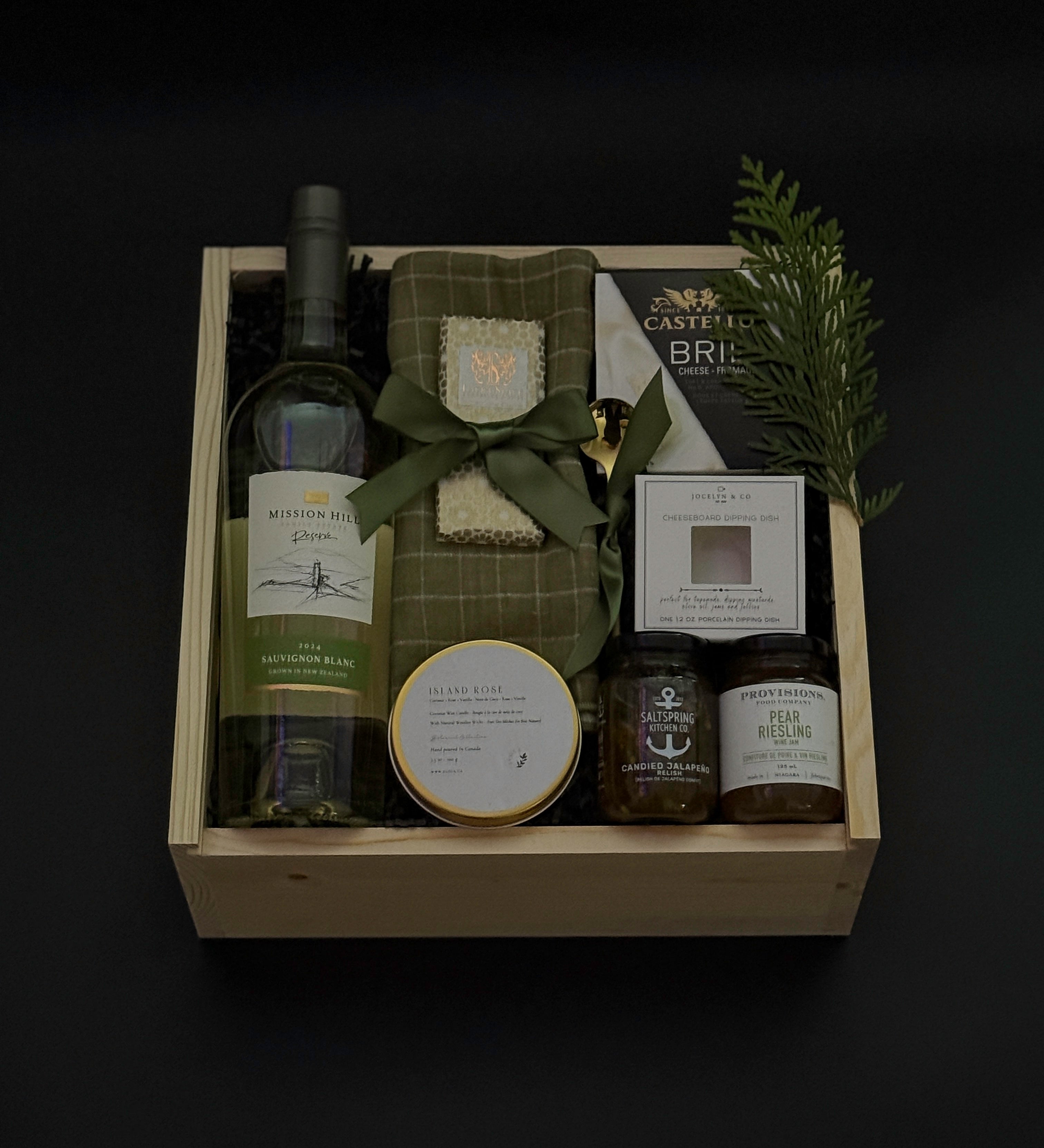 Elegant holiday wine gift box with Mission Hill Sauvignon Blanc, Brie, artisan preserves, chocolate, and charcuterie essentials. Perfect for corporate and client gifting.