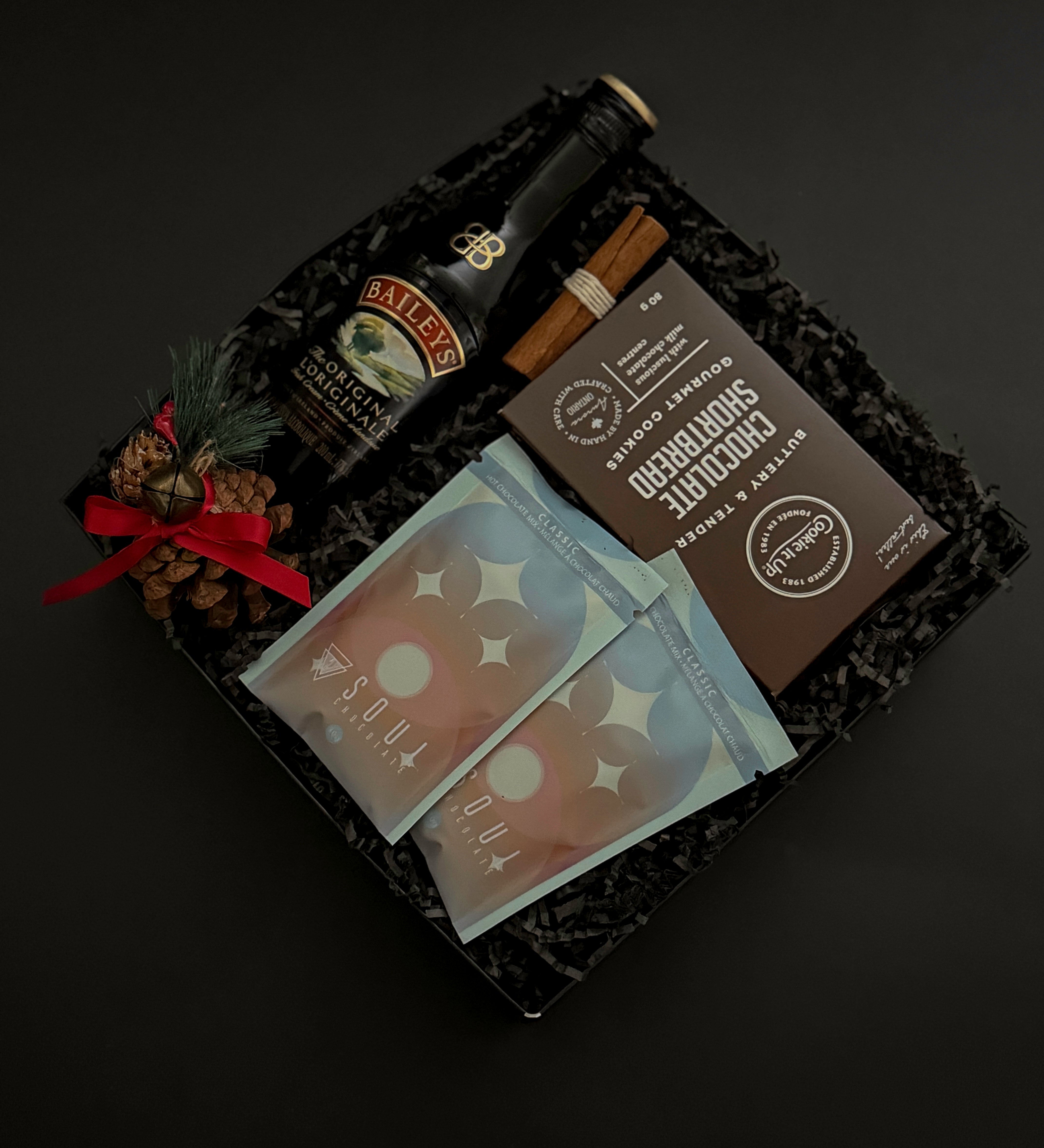 Seasonal gift basket featuring Baileys, hot chocolate, and chocolate shortbread cookies.