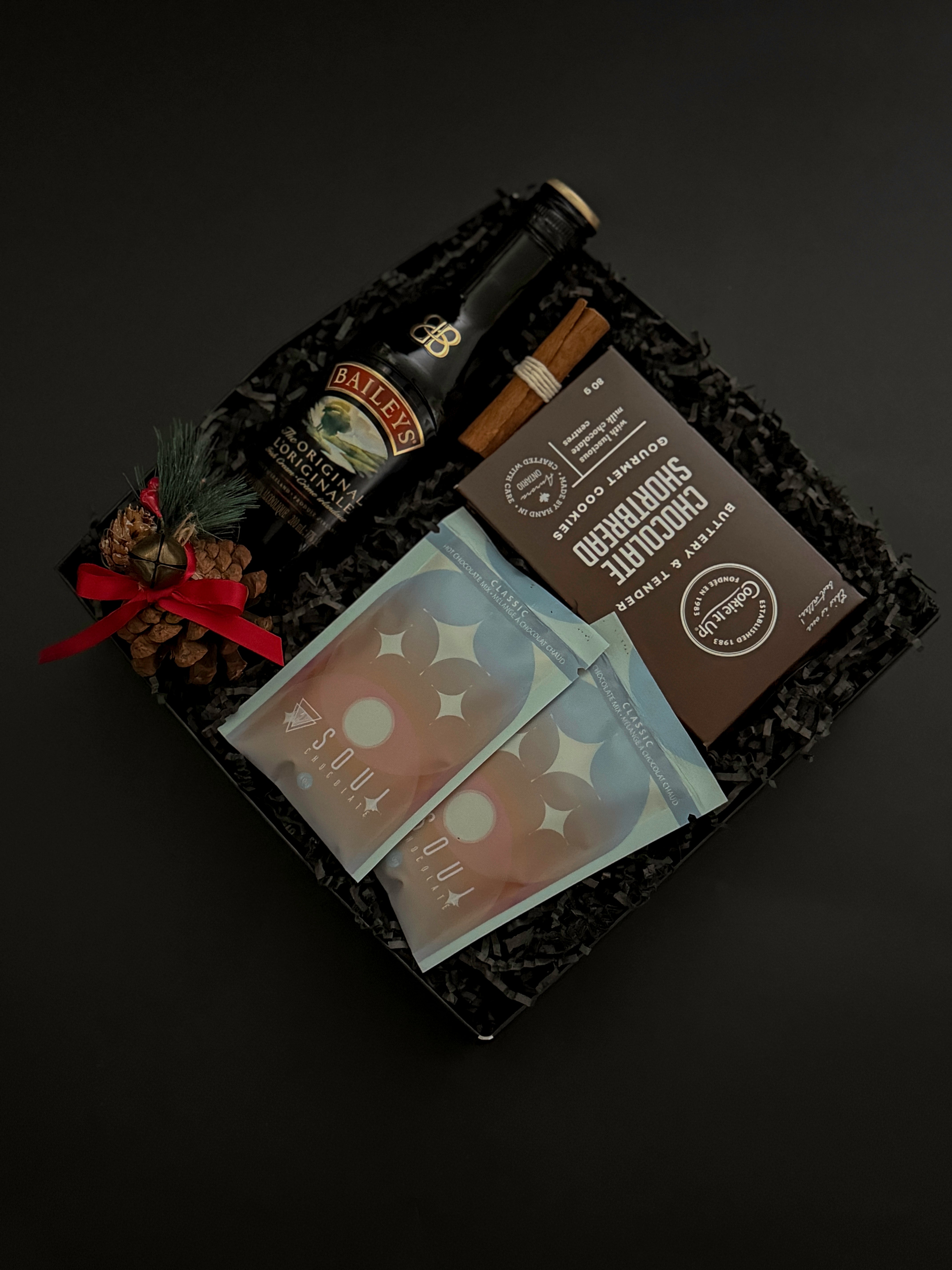 Seasonal gift basket featuring Baileys, hot chocolate, and chocolate shortbread cookies.