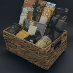 Gourmet chocolate assortment, artisanal raw honey, and forest fir candle styled in a refined metropolitan gift basket