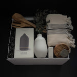 Close up of Stillness gift box featuring Gharyan Stoneware handmade vase bergamot essential oil and olive wood utensils