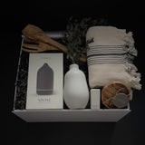 Close up of Stillness gift box featuring Gharyan Stoneware handmade vase bergamot essential oil and olive wood utensils