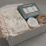 Close up of Loulou Lollipop washcloth set fringe blanket and Baby Bums cream in a white gift box