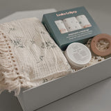 Close up of Loulou Lollipop washcloth set fringe blanket and Baby Bums cream in a white gift box