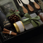 Gourmet holiday charcuterie gift box with wine, almonds, and candle for corporate gifting.