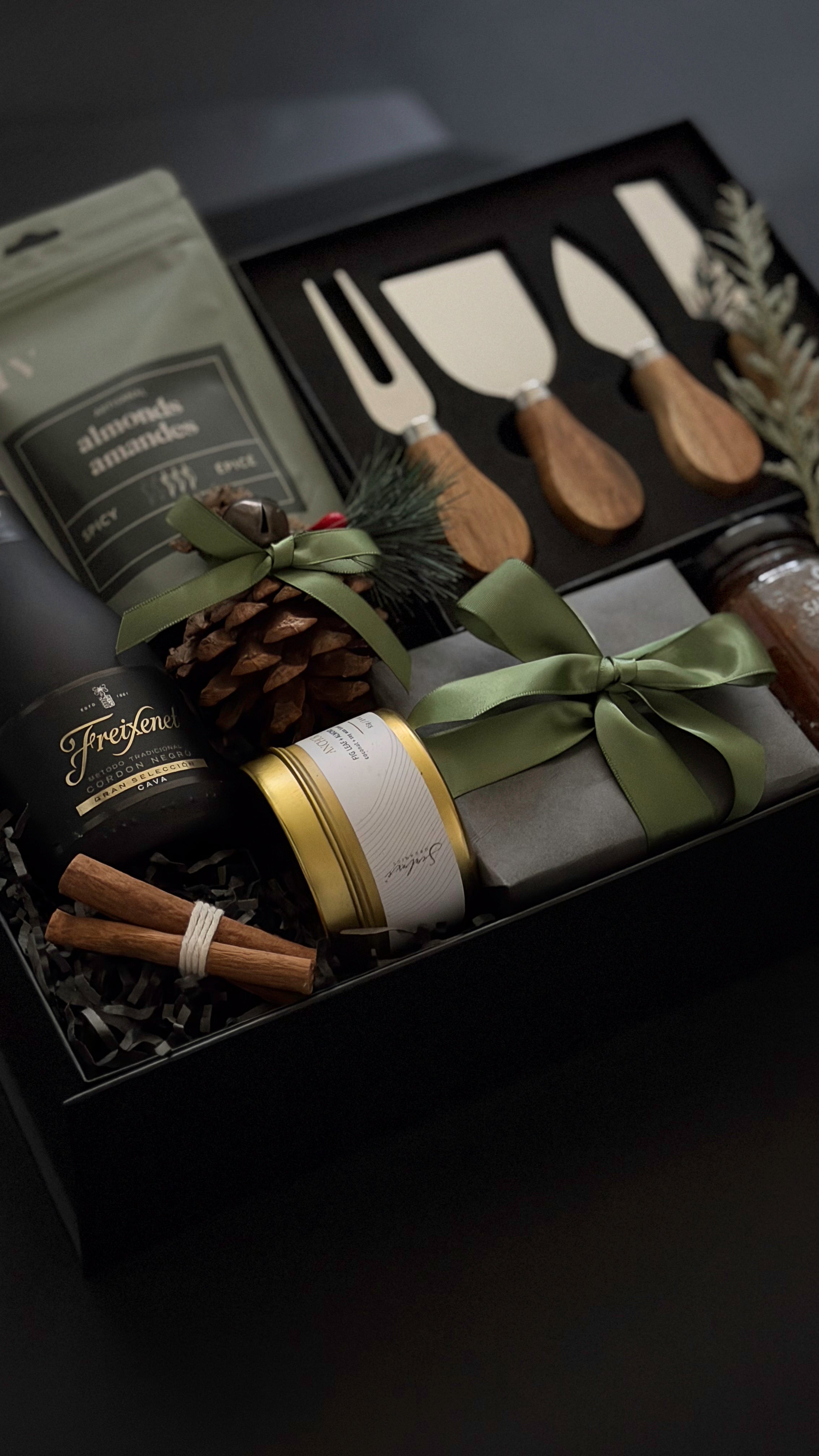 Gourmet holiday charcuterie gift box with wine, almonds, and candle for corporate gifting.
