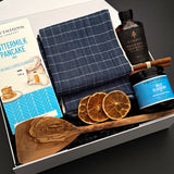 Muse Baskets and Co. holiday breakfast gift box with an olive wood spatula, navy checkered towel and Canadian pantry favourites.