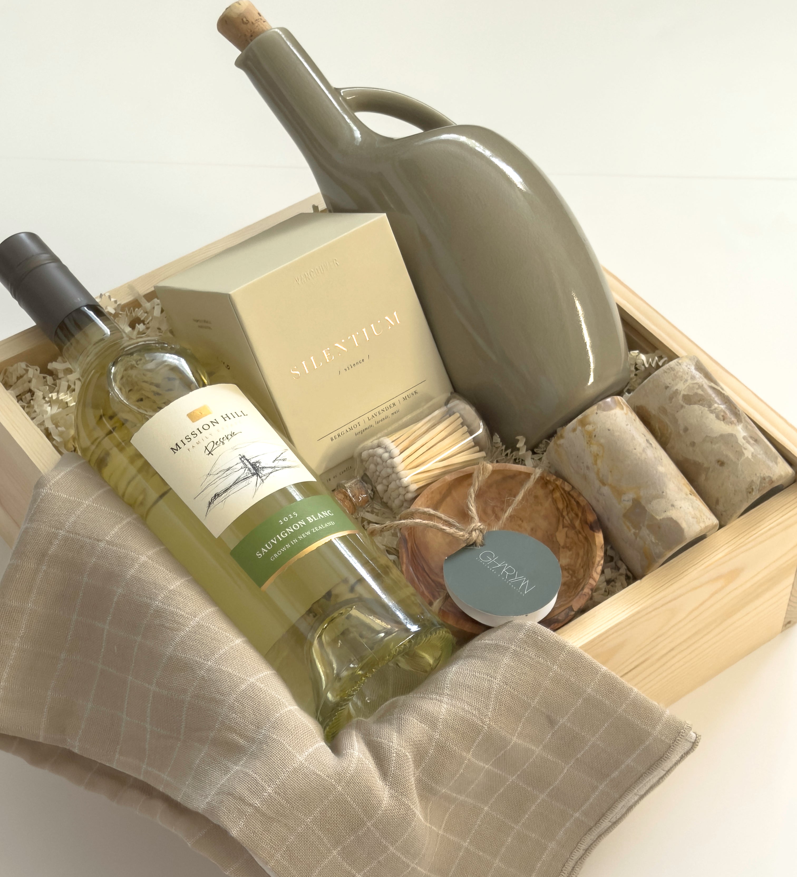 Vancouver Thanksgiving gift basket by Muse Baskets and Co. with Mission Hill wine, Vancouver Candle Co. candle, Matchstick Boutique matches, Gharyan Stoneware pieces and Danica Brands dishtowels in a wood gift box.