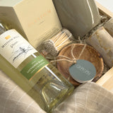 Luxury Thanksgiving gift basket by Muse Baskets and Co. with white wine, candlelight, kitchen staples and Canadian-made home goods arranged in a signature wood gift box.
