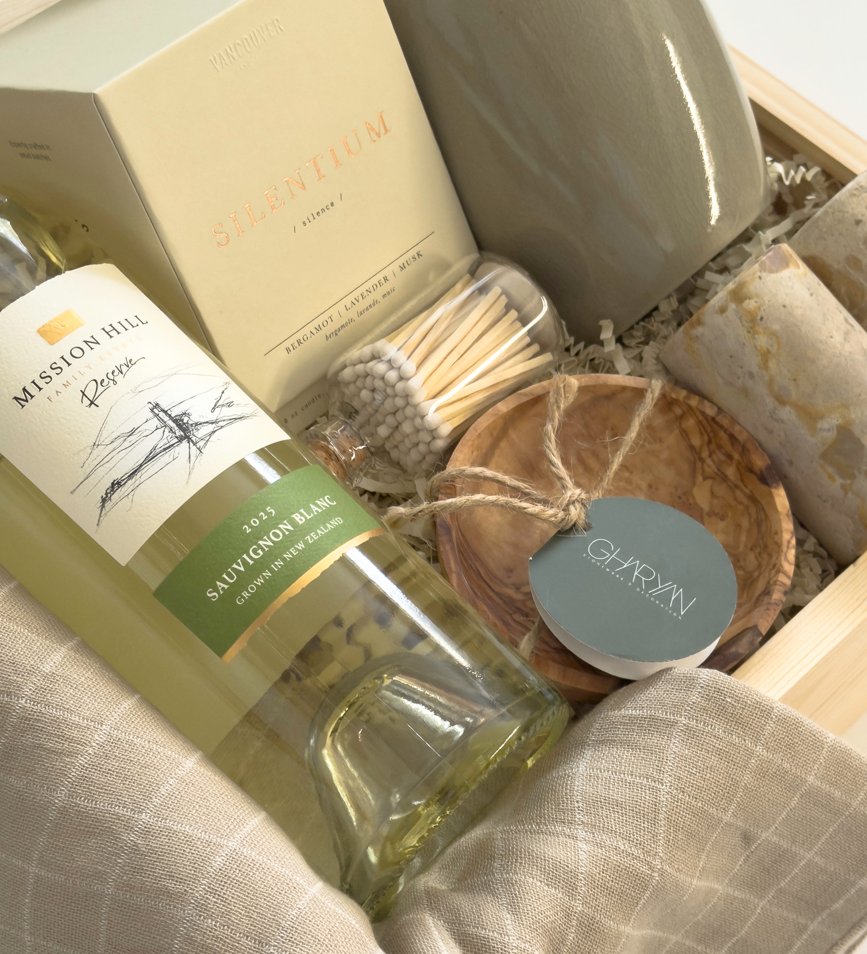 Luxury Thanksgiving gift basket by Muse Baskets and Co. with white wine, candlelight, kitchen staples and Canadian-made home goods arranged in a signature wood gift box.