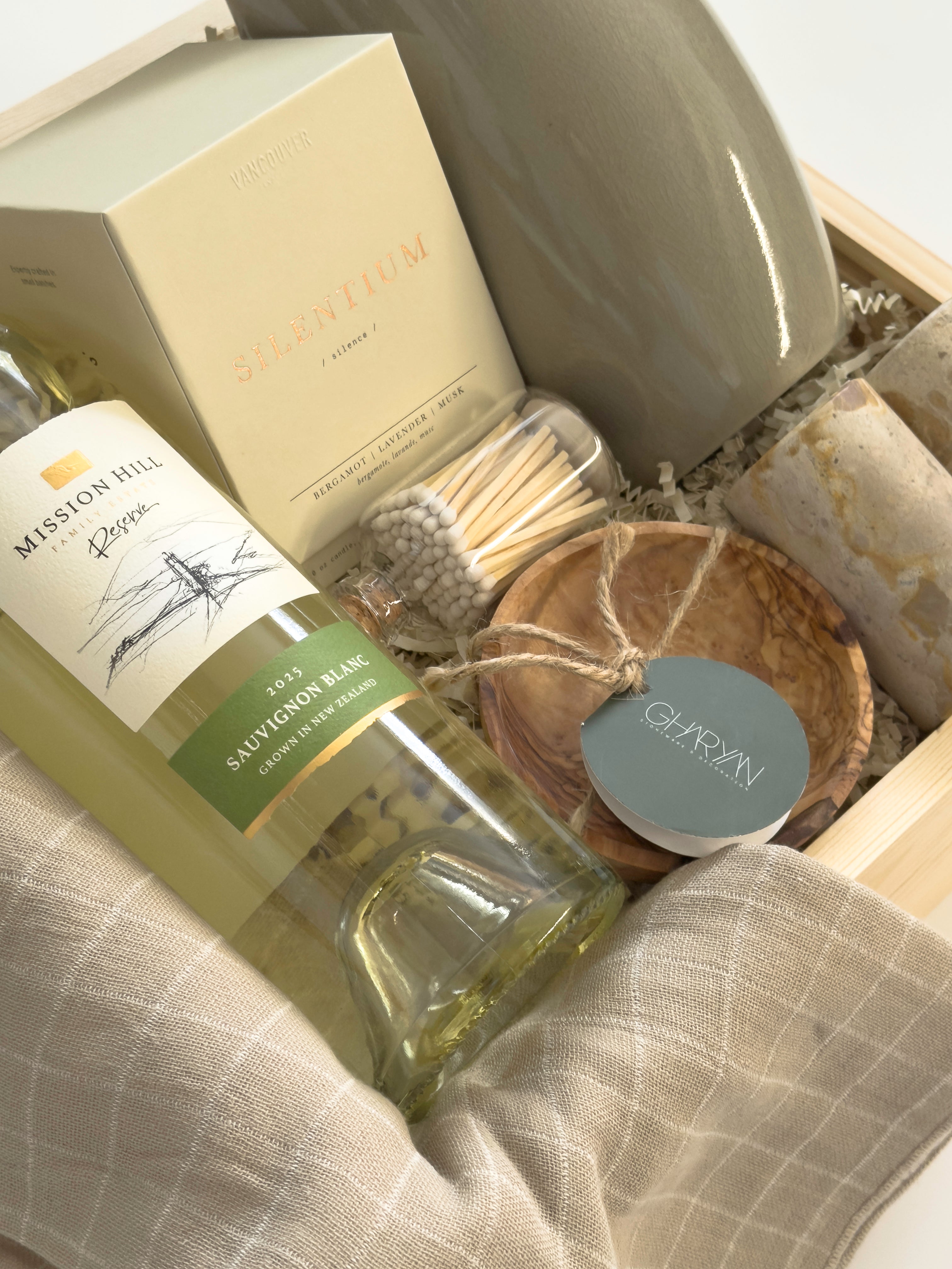 Luxury Thanksgiving gift basket by Muse Baskets and Co. with white wine, candlelight, kitchen staples and Canadian-made home goods arranged in a signature wood gift box.