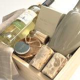 Realtor and client appreciation gift basket by Muse Baskets and Co. featuring wine, candle, stoneware, marble salt and pepper shakers, olive wood and soft grey dishtowels for a refined home gifting experience.