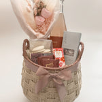 In Her Bloom luxury Mother's Day and client appreciation gift basket for her featuring Sidney Sparkling Rosé, preserved blush rose bouquet by Hugme Florals, Sealuxe Organics Ritual Rose Bath Tea, and Canadian artisan chocolates in a handwoven wicker basket with mauve satin ribbon by Muse Baskets and Co Vancouver