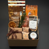 Cedar & Clove holiday gift box by Muse Baskets and Co. with maple pecans, brie, salmon and chocolate in a kraft box finished with brown satin ribbon.
