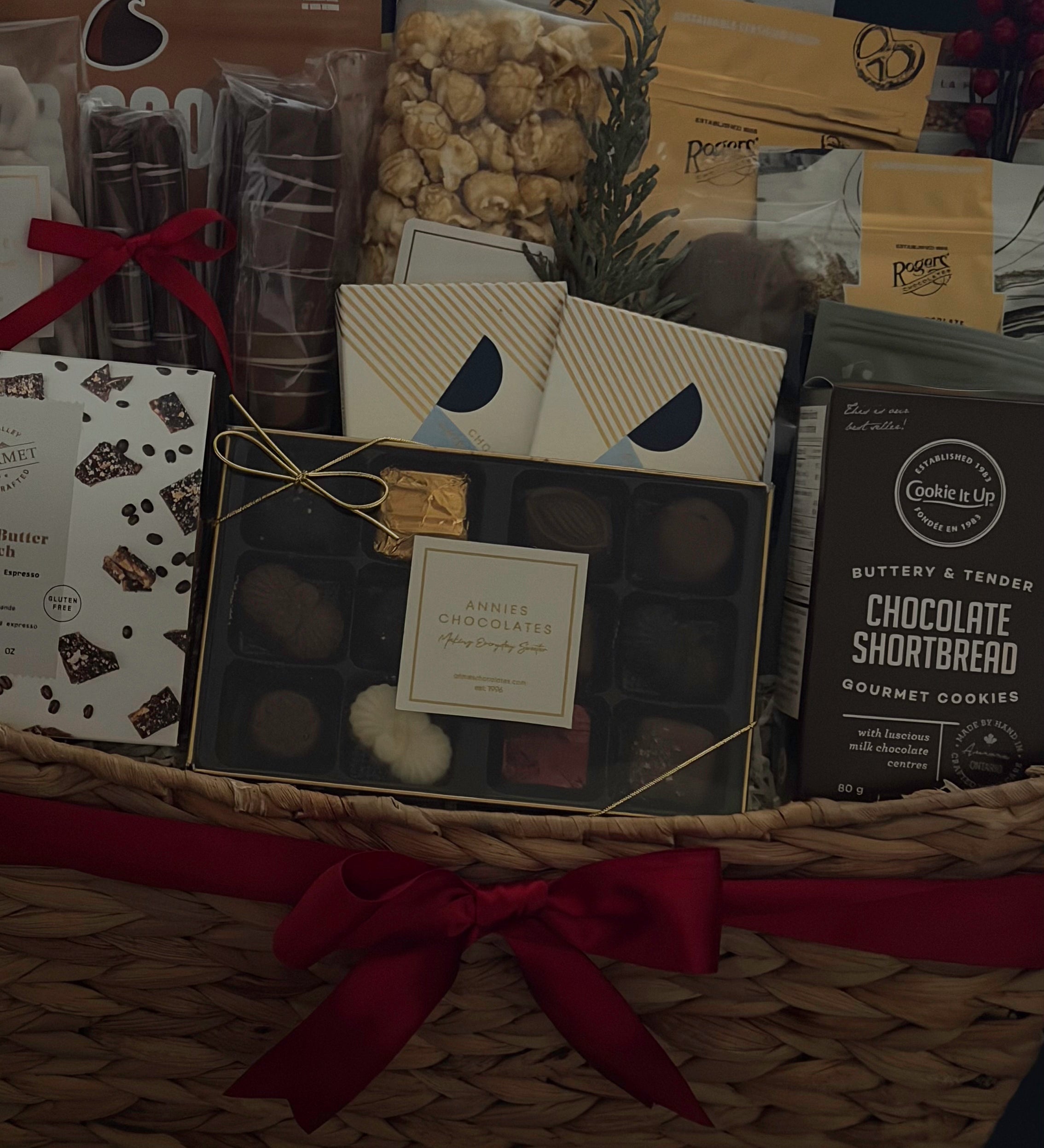 Holiday office share gift basket with chocolate, popcorn, and cookies.