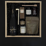 Corporate client gift box with sparkling wine, chocolate, almonds, and artisan candle.