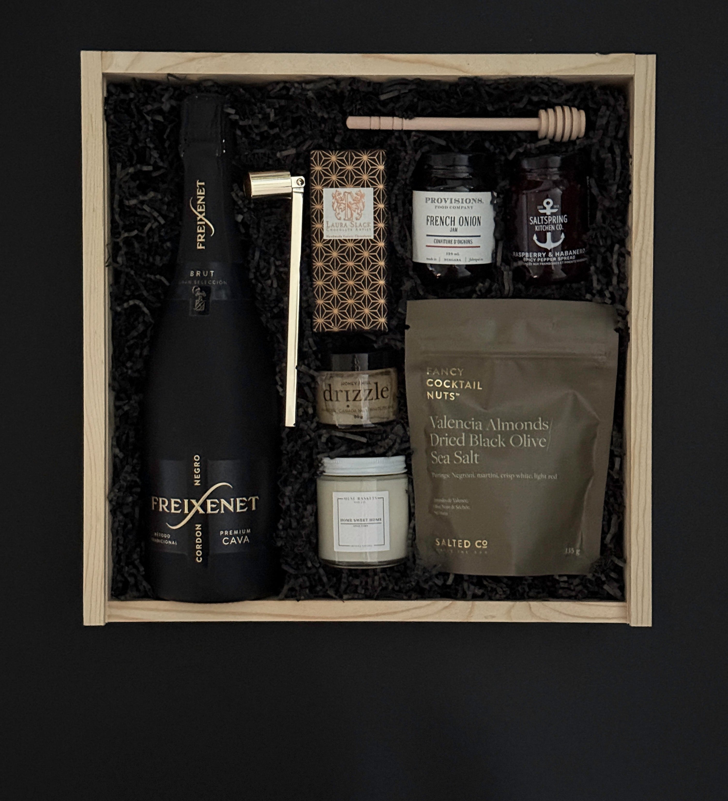 Corporate client gift box with sparkling wine, chocolate, almonds, and artisan candle.